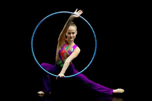 A girl gymnast performs an exercise with a hoop. The concept of gymnastics and fitness. Isolated.