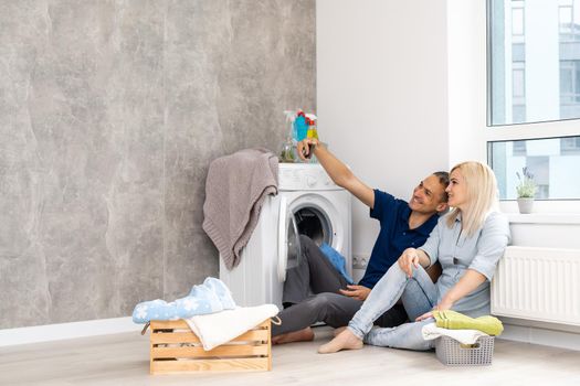 man and woman with washing machine in apartment