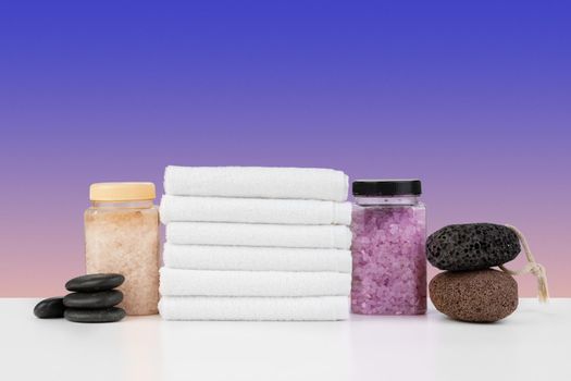 Bath towels and spa salt on white table, close up