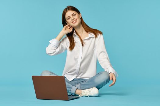 woman with laptop learning internet online education blue background. High quality photo