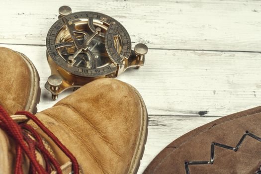 Hiking boots with travel accessories on grunge background. Close up.