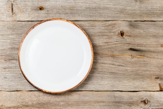 Empty white ceramic dish on rustic wooden table