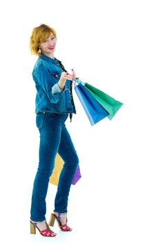 A beautiful young woman happily shopping with large multi-colored paper bags. The concept of sales, upcoming holidays. Isolated on white background.