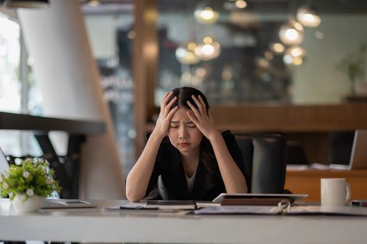 Stressed business woman working on laptop looking worried, tired and overwhelmed. asian female headache suffer from bad blurry weak vision tired of computer work syndrome, sight problem concept.