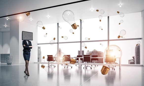 Business woman in suit with TV instead of head keeping arms crossed while standing among flying and glowing lightbulbs inside office building. 3D rendering.
