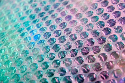 Abstract trendy holographic background in the style of the 80-90s. Real texture of bubble wrap film in bright acid colors. Synthwave Vaporwave webpunk Massurrealism aesthetics.