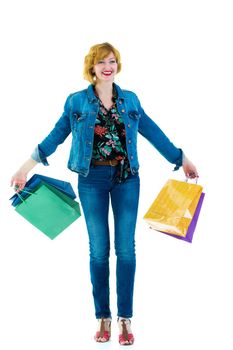 A beautiful young woman happily shopping with large multi-colored paper bags. The concept of sales, upcoming holidays. Isolated on white background.