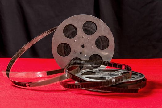 reel of film on a red table with black background