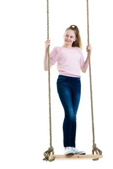 School-age teenage girl swinging on a swing. The concept of rest after class. Isolated on white background.