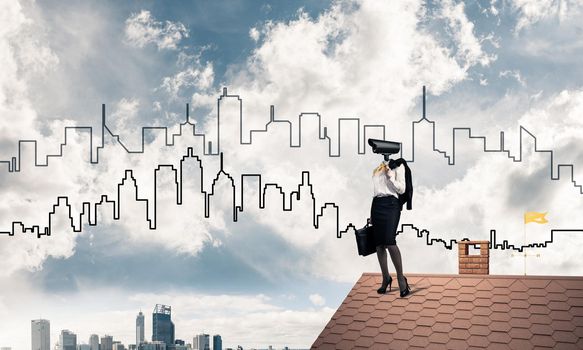 Faceless businesswoman with camera zoom instead of head standing on house roof