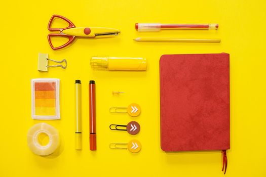 School supplies. Yellow and red colors. Flat lay composition. Yellow background. Space for text. Back to school.