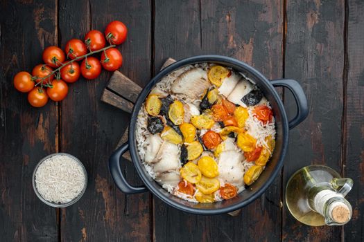 One pan fabulous fish, with basmati rice and cherry tomatoes, on old wooden table, top view