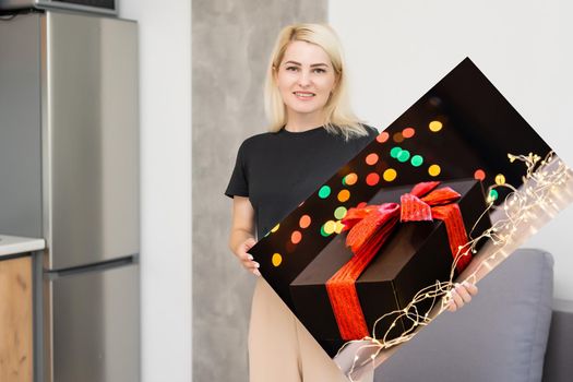 woman holding a photo canvas with a picture of christmas.