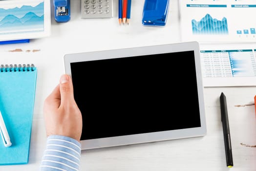 close-up of men's hands with a computer tablet. Businessman works in the office