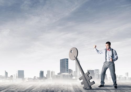 Determined businessman against modern cityscape breaking with fist stone key figure