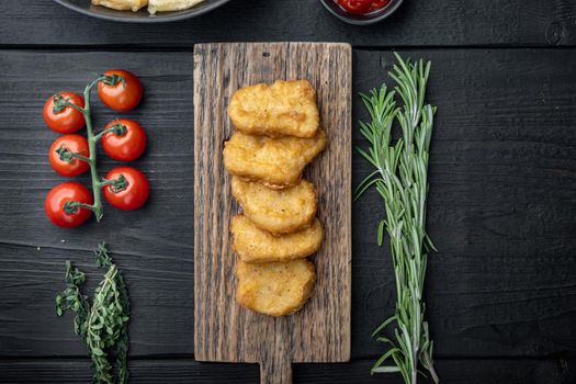 Chicken breast nuggets fried on black wooden background, flat lay, with space for text.