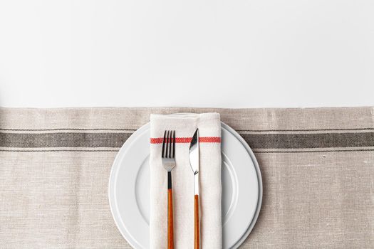 Fork, knife and plate on towel. Isolated on white background. Close up.
