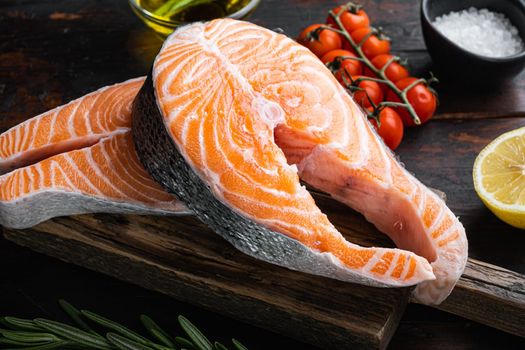 Slice of red fish trout with herbs, on old wooden table.