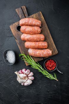 Traditional pork sausages, flat lay, on black background.