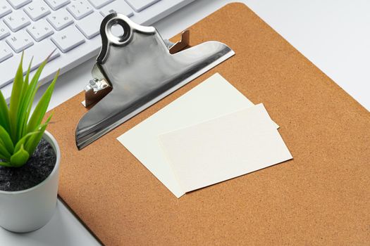 Blank business cards with supplies and keyboard on office table. Close up.