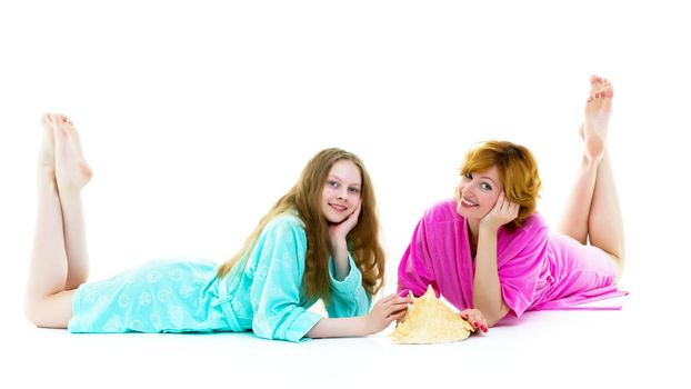 Daughter and mother in bath robes in a photo studio. The concept of relaxation, cosmetics. Isolated on white background