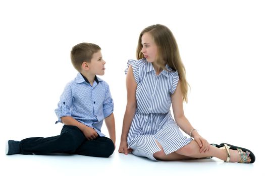 Boy and girl, brother and sister posing in the studio. Concept of family values, friendship, game. Isolated on white background