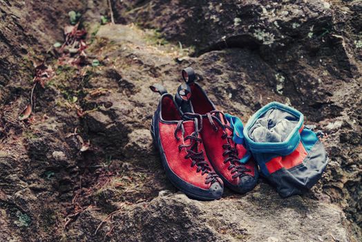 Climbing shoes and sack with magnesium powder on stone rock