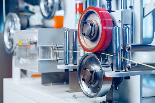 Inside a modern plant producing power electric cables and optical fibers. .Cable manufacturing machine part. Close up.