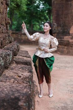 happy beautiful woman inThai traditional dress is pointing
