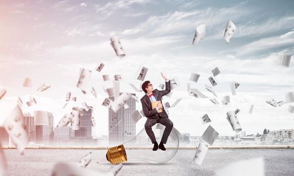 young businessman with a book. flying around papers in chaos