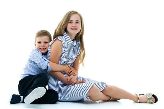 Boy and girl, brother and sister posing in the studio. Concept of family values, friendship, game. Isolated on white background