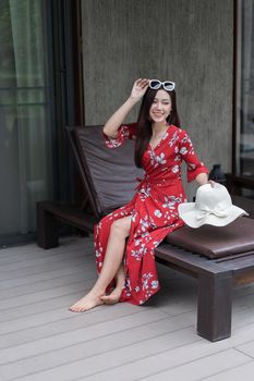 portrait of woman sitting on chair near swimming pool