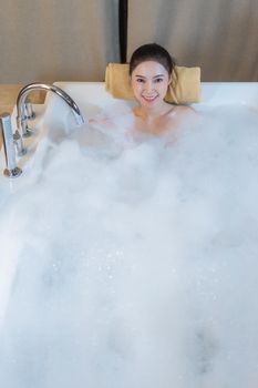 beautiful woman takes bubble bath and playing in bathtub