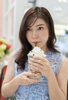 woman drinking a cup of chocolate milk at a cafe