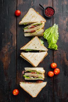 Fresh sandwiches with ingredient, on dark wooden background, top view