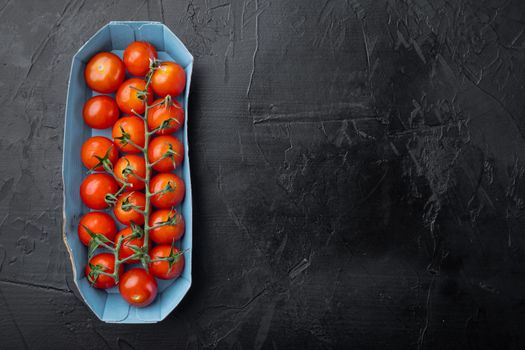 Red ripe cherry tomatoes, on black background with copy space for text