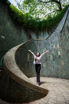 woman hands up at underground crossing in tunnel at Fort Canning Park, Singapore