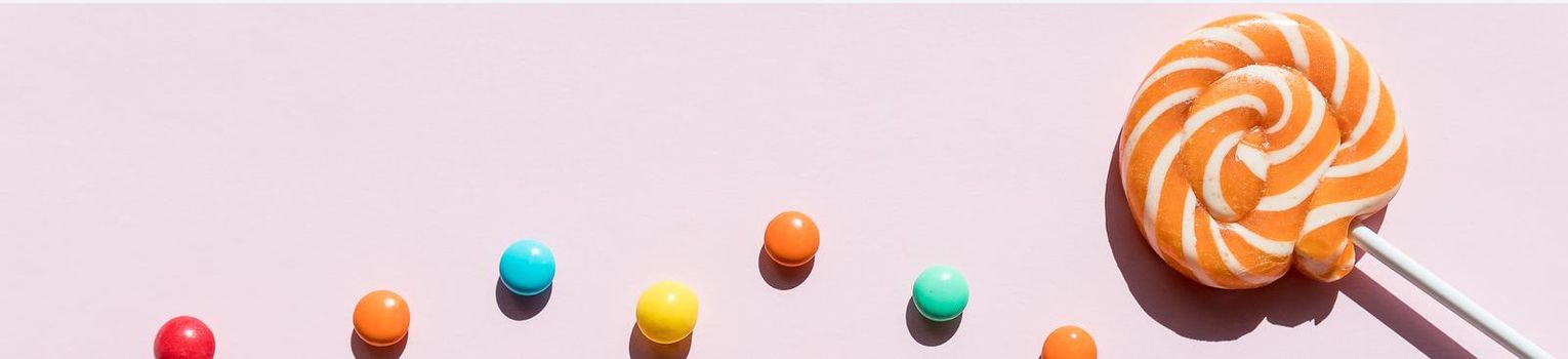 Assortment of sweet candies on color background
