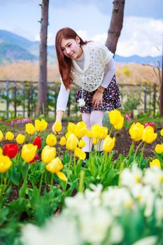 beautiful woman with tulips flowers in the garden
