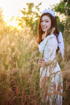 beautiful angel woman in a grass field with sunlight