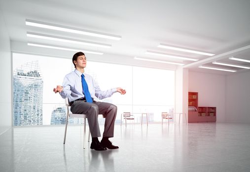 young businessman in the office meditates, achieve calmness, to achieve the goal