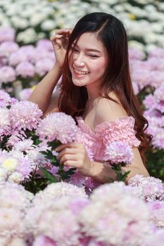 beautiful woman in colorful chrysanthemum glower garden 