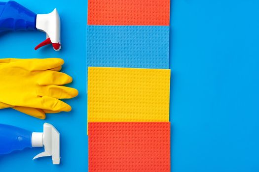 House cleaning supplies on blue color background, top view