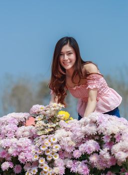 beautiful woman in colorful chrysanthemum glower garden 