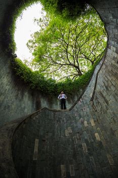 woman staning at underground crossing in tunnel at Fort Canning Park, Singapore