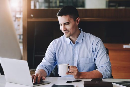 Male marketing managers drink coffee while working to reduce drowsiness before using computers, iPads, and marketing analysis papers