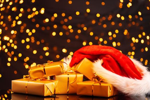 Wrapped Christmas gifts on golden lights bokeh background close up