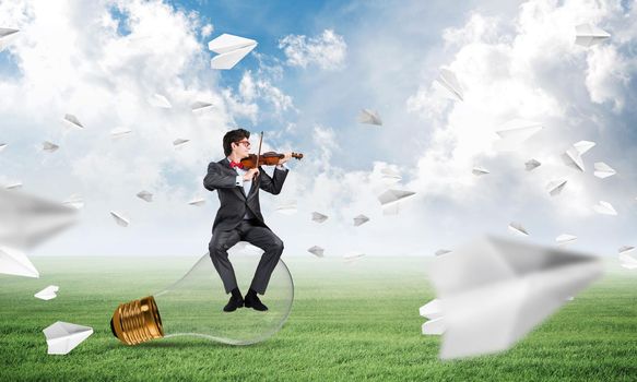young businessman plays the violin, the concept of creativity in business