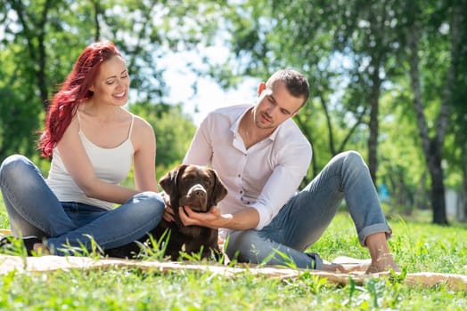 A couple and their dog in the park. Spending time with friends
