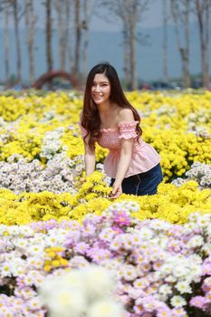 beautiful woman in colorful chrysanthemum glower garden 